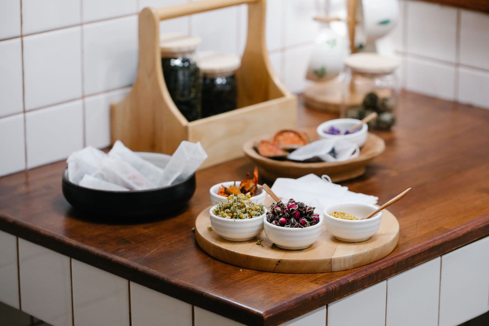 An assortment of dried herbs and spices in bowls on a table
